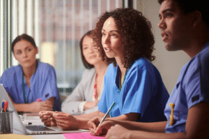 Healthcare staff discussing an incident response plan around a conference table.